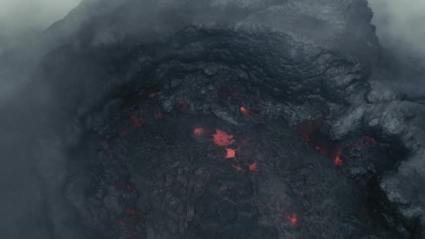 Bursts of orange lava in a volcano crater surrounded by smoke and steam