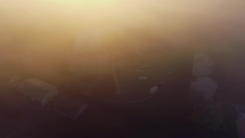 Fog defuses sun obscuring neighborhood buildings