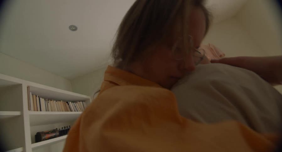 Two women hug tightly and sway in bedroom