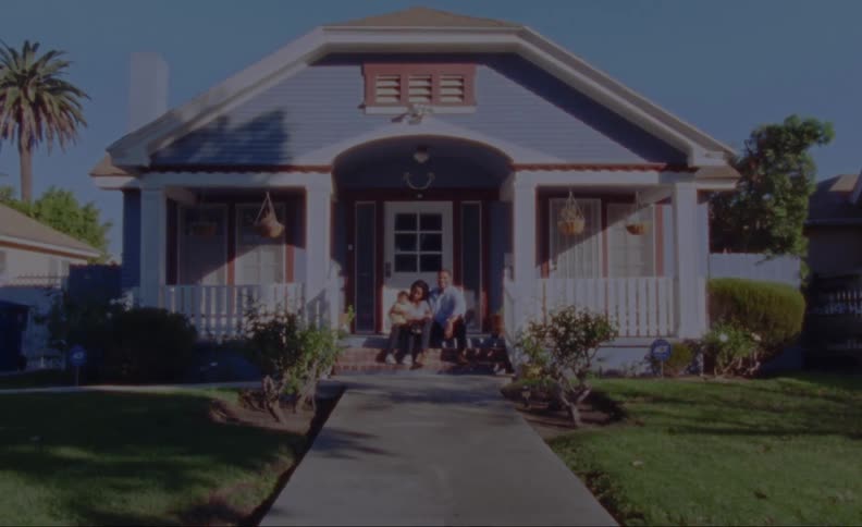 Young family sits on front porch steps