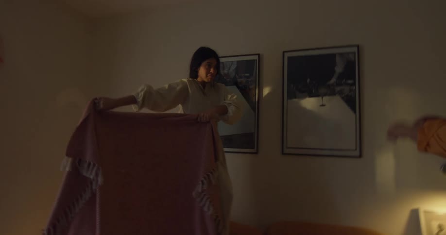 Two women role play a matador and a bull in bedroom