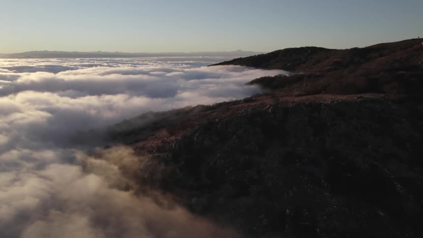 A thick layer of cloud cover reaches onto shore