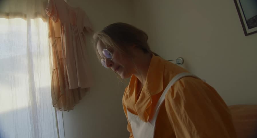A woman laughs during a conversation in her living room