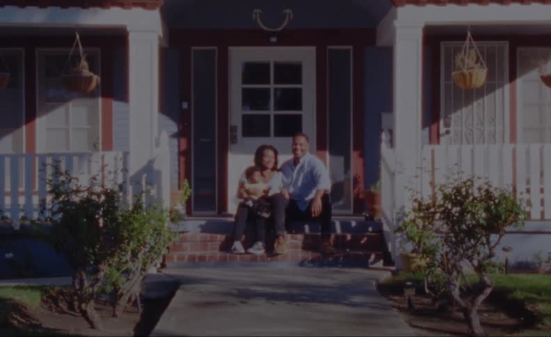 Father mother and son sit on porch posing for camera