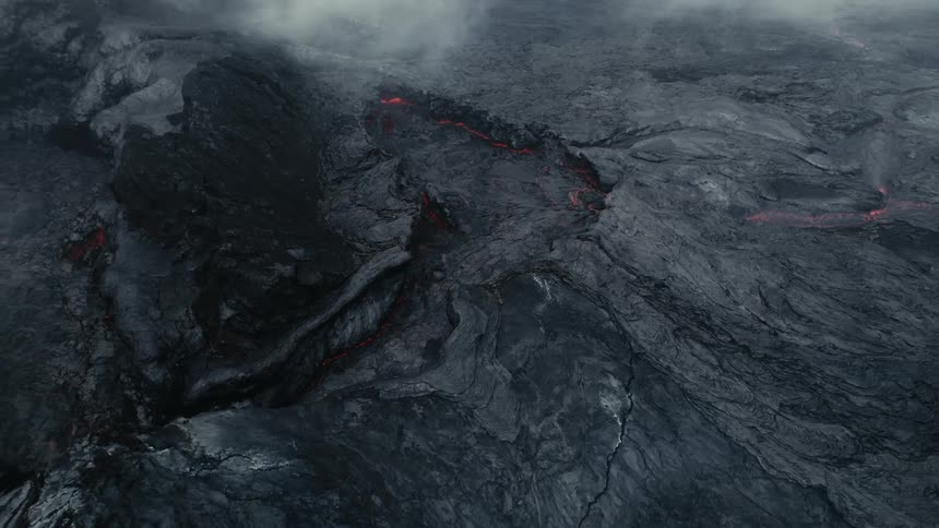 Lava spurts from beneath ash in volcanic region