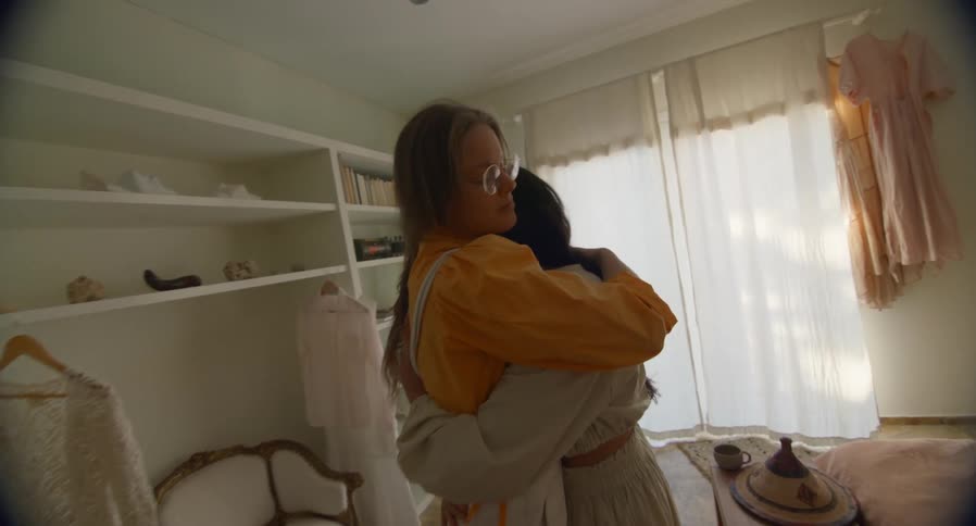 Couple of women slow dance in each others arms in the bedroom