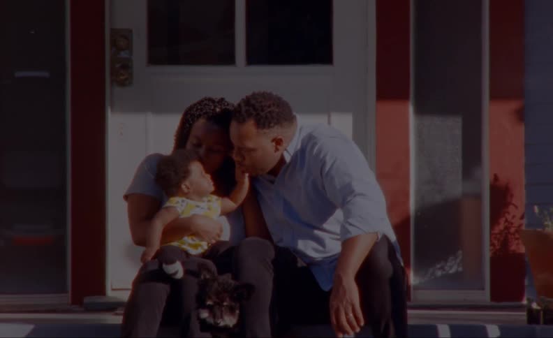 A family is sitting together outdoors in the daytime