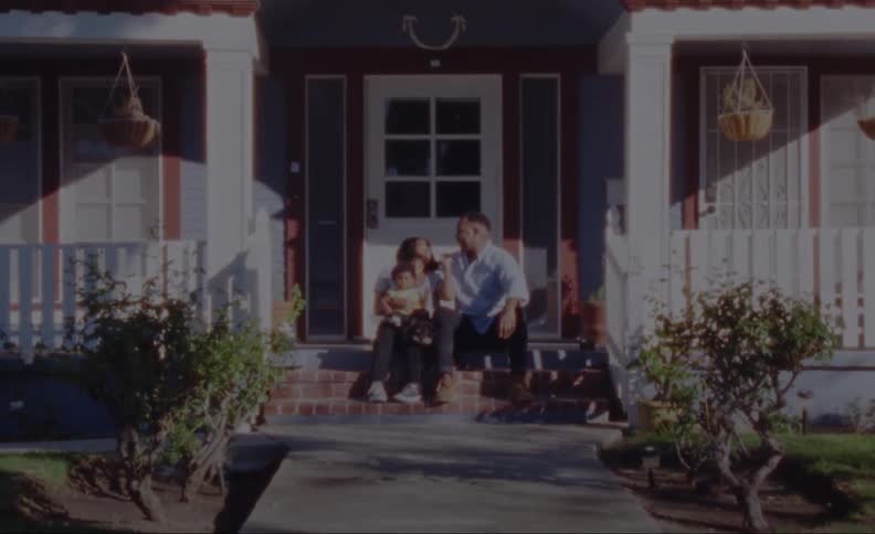 A family is sitting outdoors on a patio