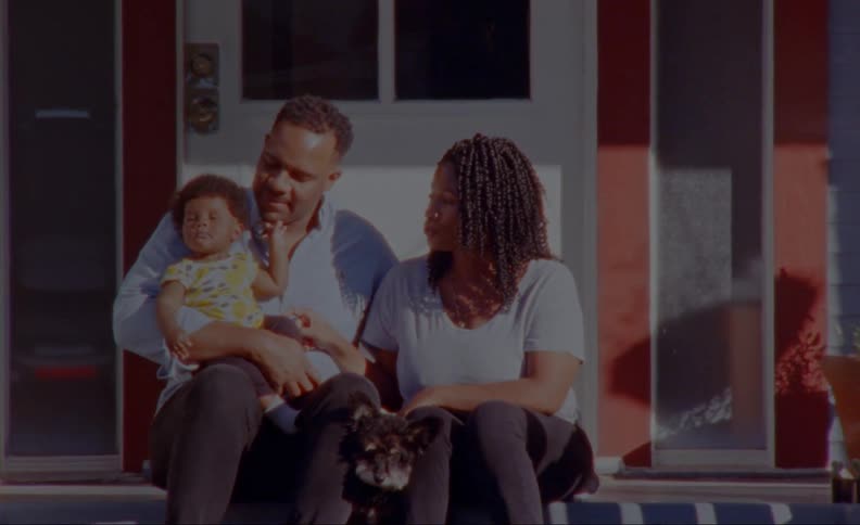 A family is sitting outdoors on their patio together