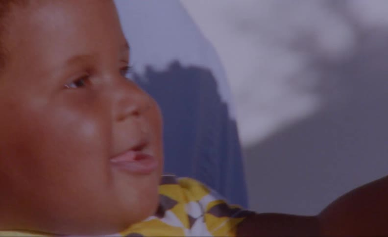 Mother mouths at childs hand as toddler reach out