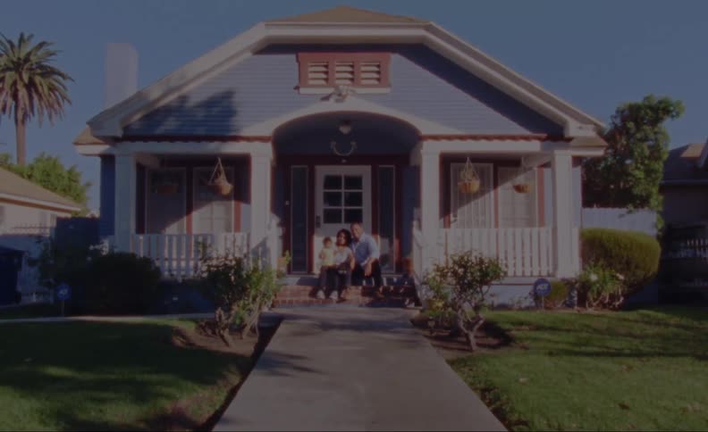 A family is sitting outside of their house together in spring