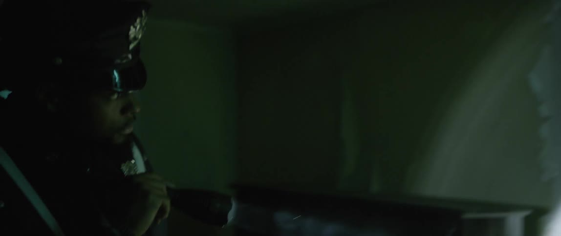 An officer is searching through a dark home