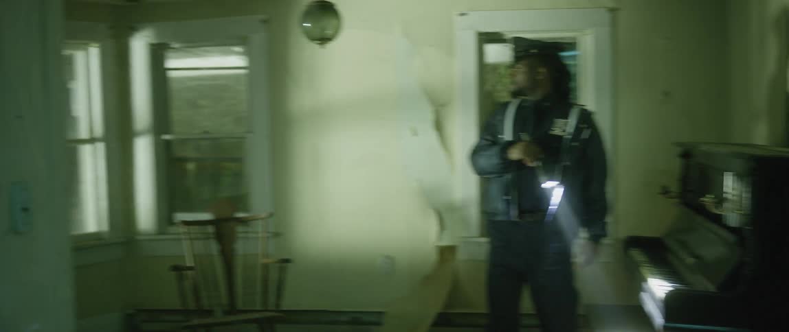 An officer is searching a home with a flashlight