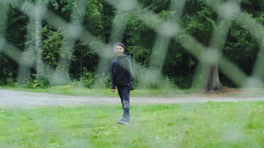 A young boy kicks a soccer ball to the goal