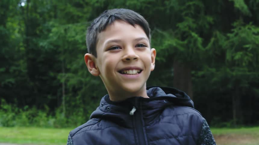 A boy is playing with a frisby outdoors in spring
