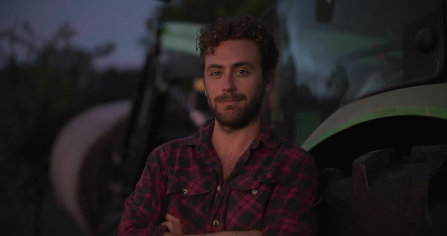 A man is standing outside by the tractor
