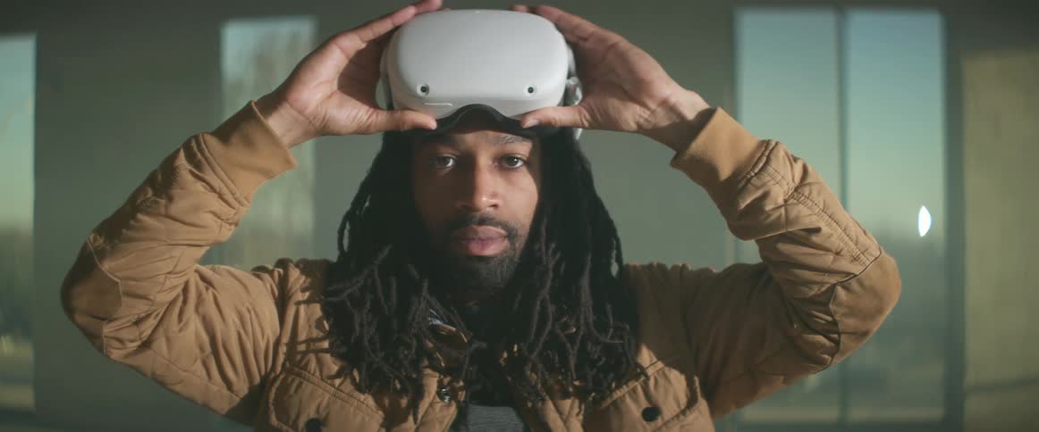 A man is standing and putting on a virtual reality headset