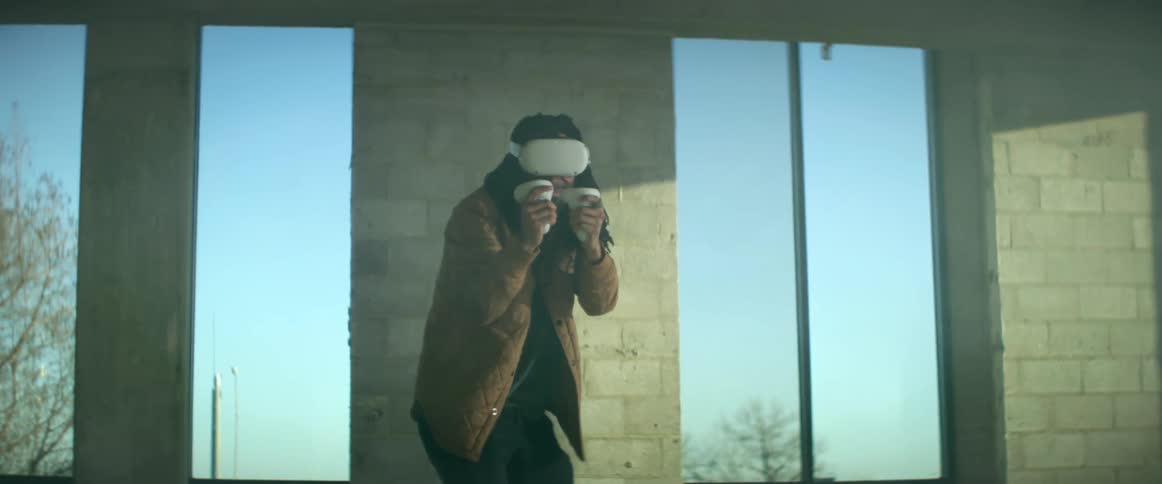 A man is playing virtual reality in a room during the daytime