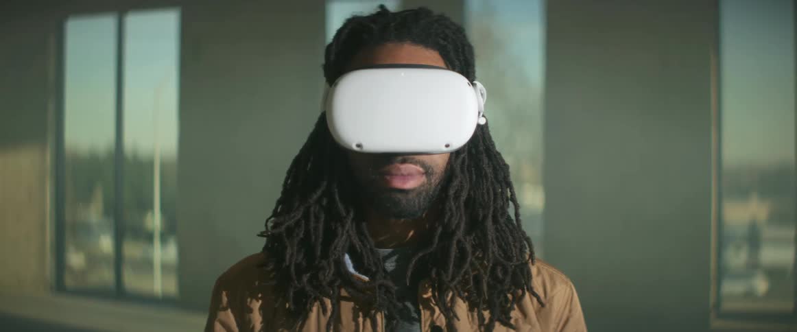 A man is wearingvirtual reality equipment indoors