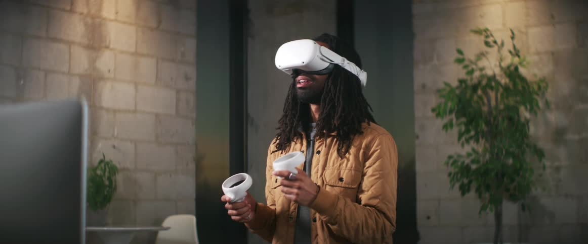 A man is indoors and playing a virtual reality game