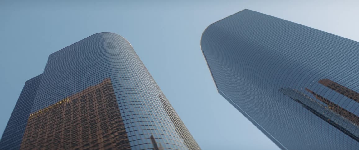 Glass facade of tall skyscrapers in the city skyline against a blue sky at morning