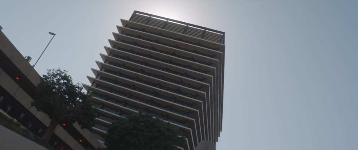 The tall building has a parking garage next door