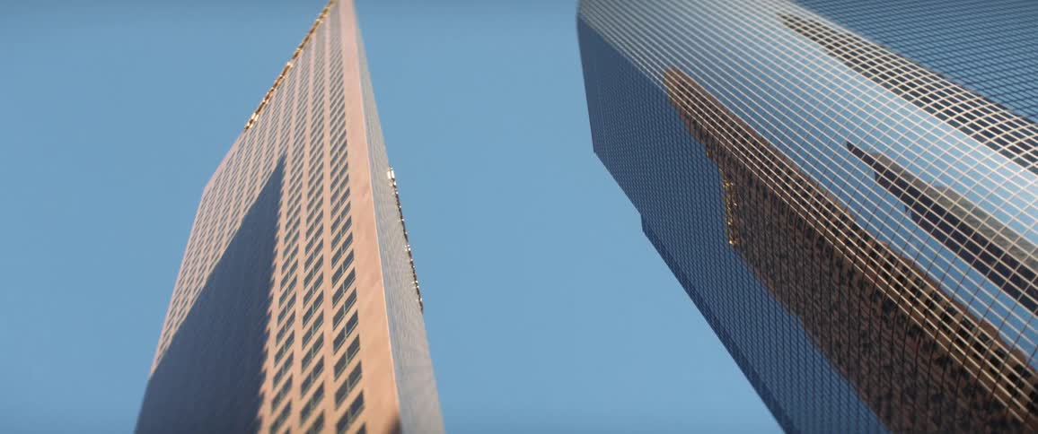 Downtown skyscraper covered in glass reflects other skyscrapers