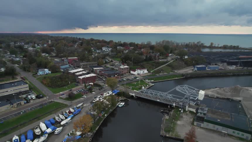 Aerial view of a community along the coast and cars traveling over a bridge