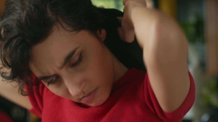 A woman is putting her hair in a ponytail