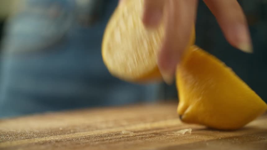 Woman with jeans takes half lemon in the kitchen