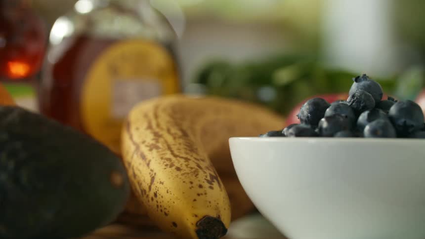 Fruit sit on counter near glass jars full of syrup