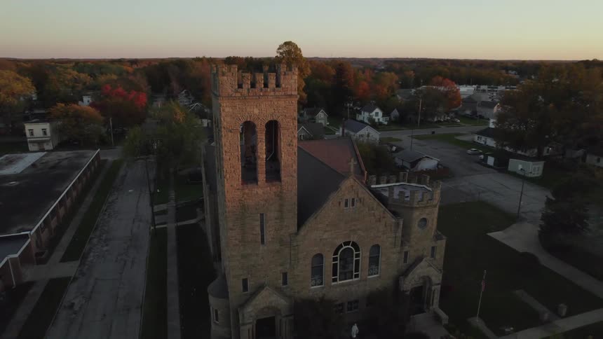 A church on a neighborhood street with a car driving down the street