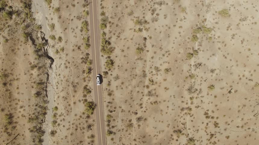 Aerial view of white van driving on highway in desert