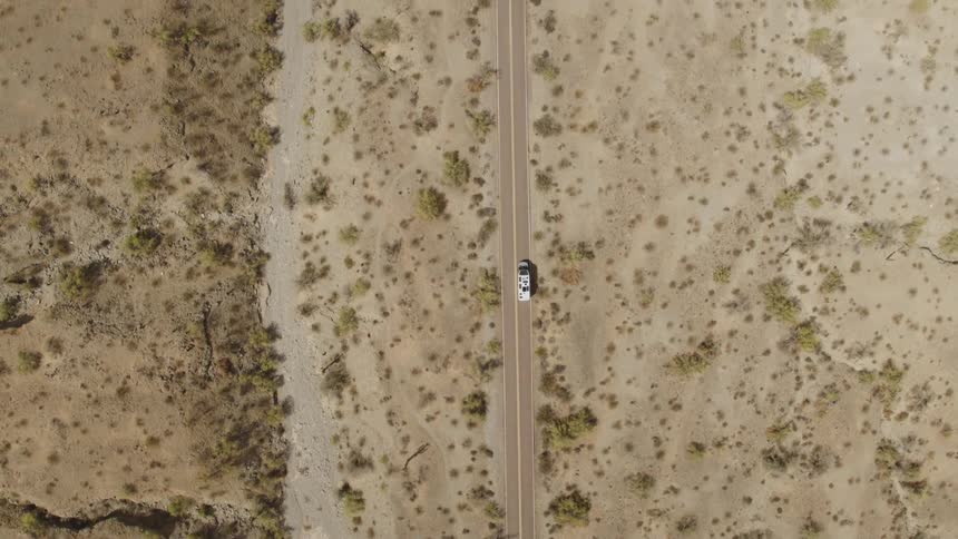 The vehicle drives on the highway through the desert