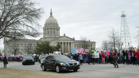 Protesters with signs walk in the street