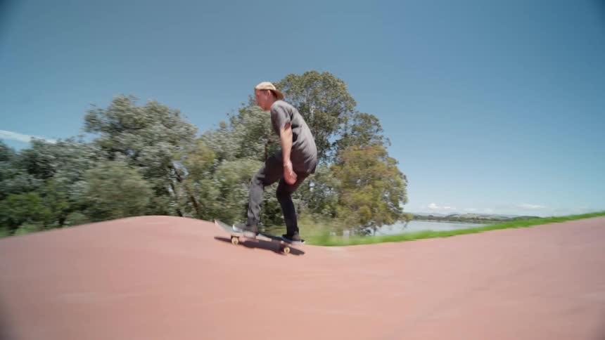 Young man skateboarding on a skateboard park at daytime
