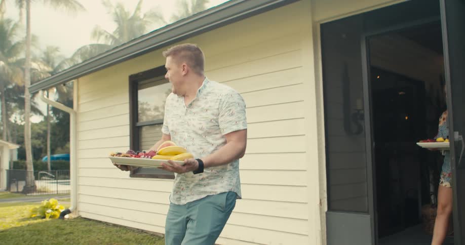 Man and woman are bringing food out into their yard