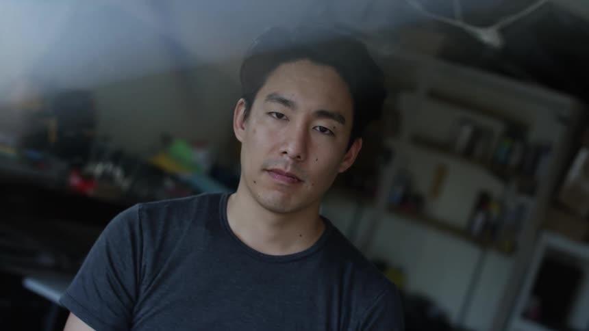 Man stands with his eyes closed in garage