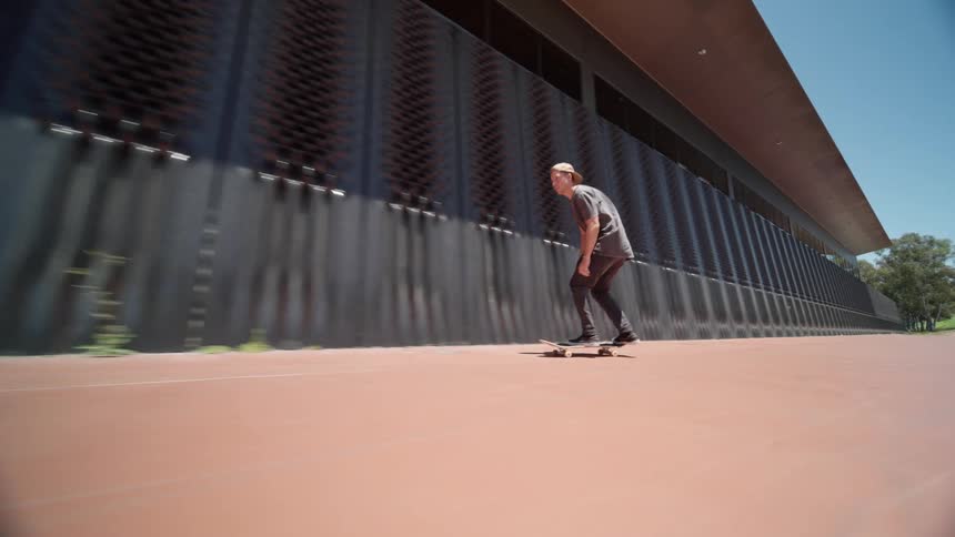 A man riding his skateboard jumping over grates in the ground