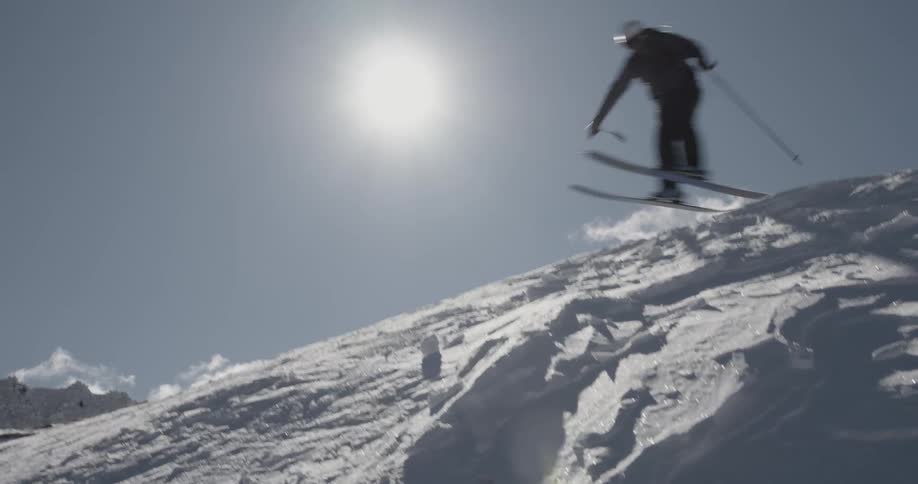 A man is skiing down a mountain in winter