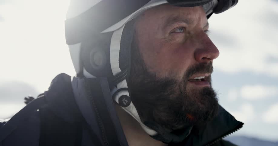 A man is standing outdoors and wearing a helmet