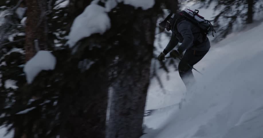 A man skis down a snow covered mountain