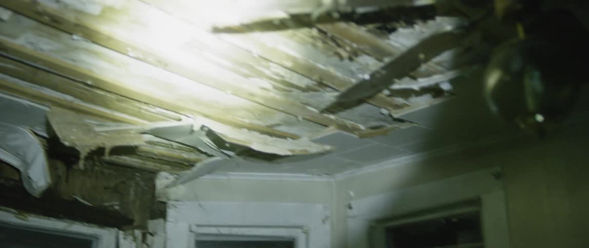 A flashlight lights up a run down room in a home