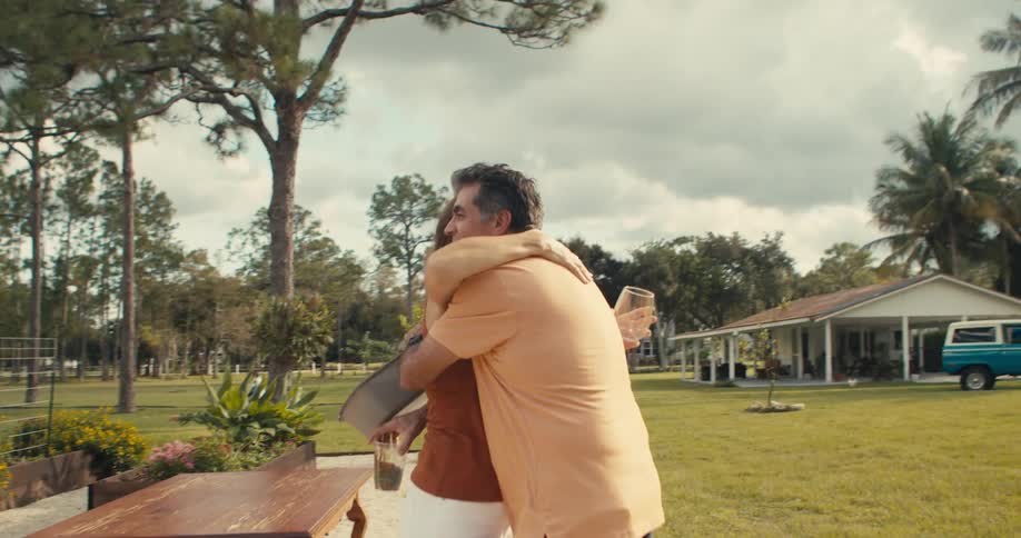 A man and woman greet each other with a hug