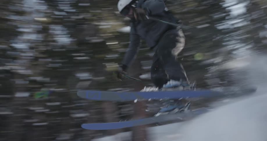 A skier going over a jump and crashing to the ground on a sunny winter day