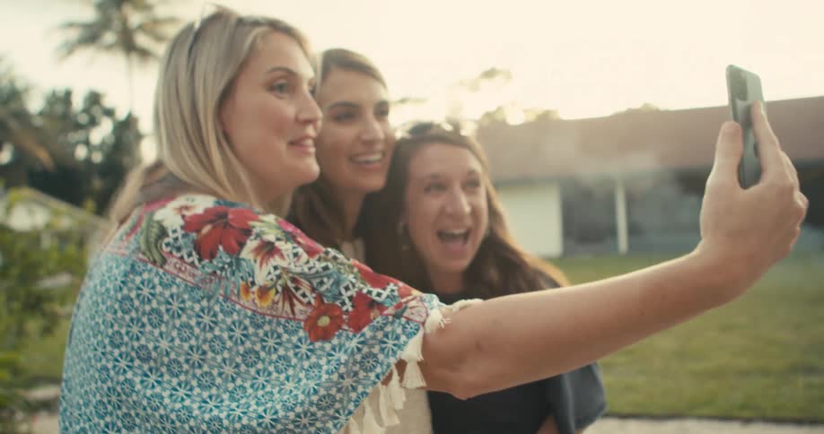 Group of happy friends on a party get together for a call on a smartphone