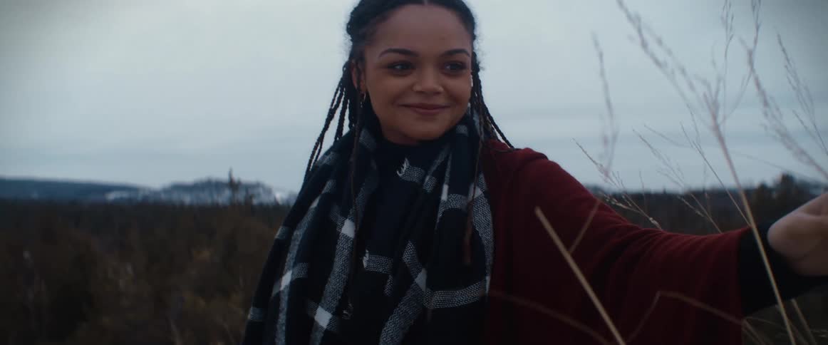 A woman is standing outdoors in a rural area