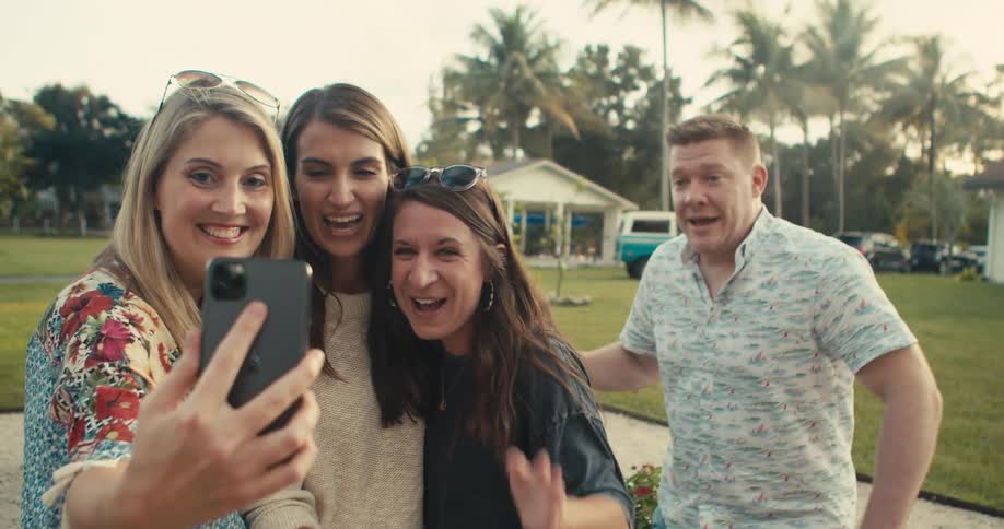 A group of friends are taking a selfie outdoors together