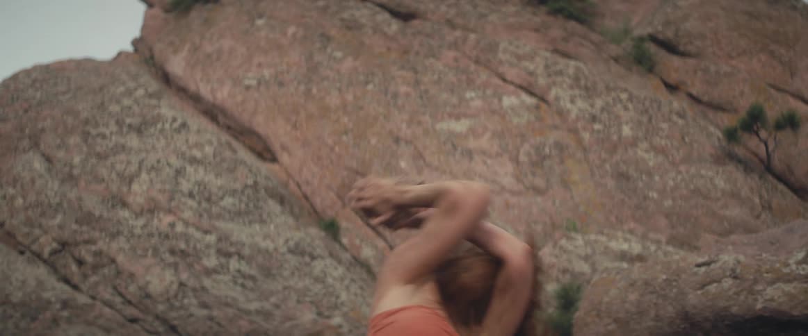 A woman lifts a stone and throws it