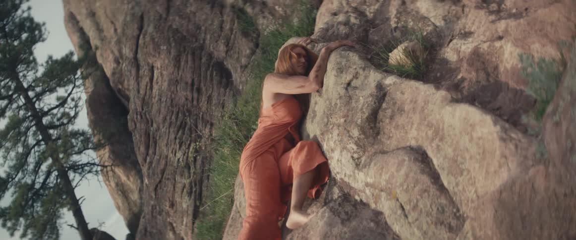 A woman is laying on the rocks hurt
